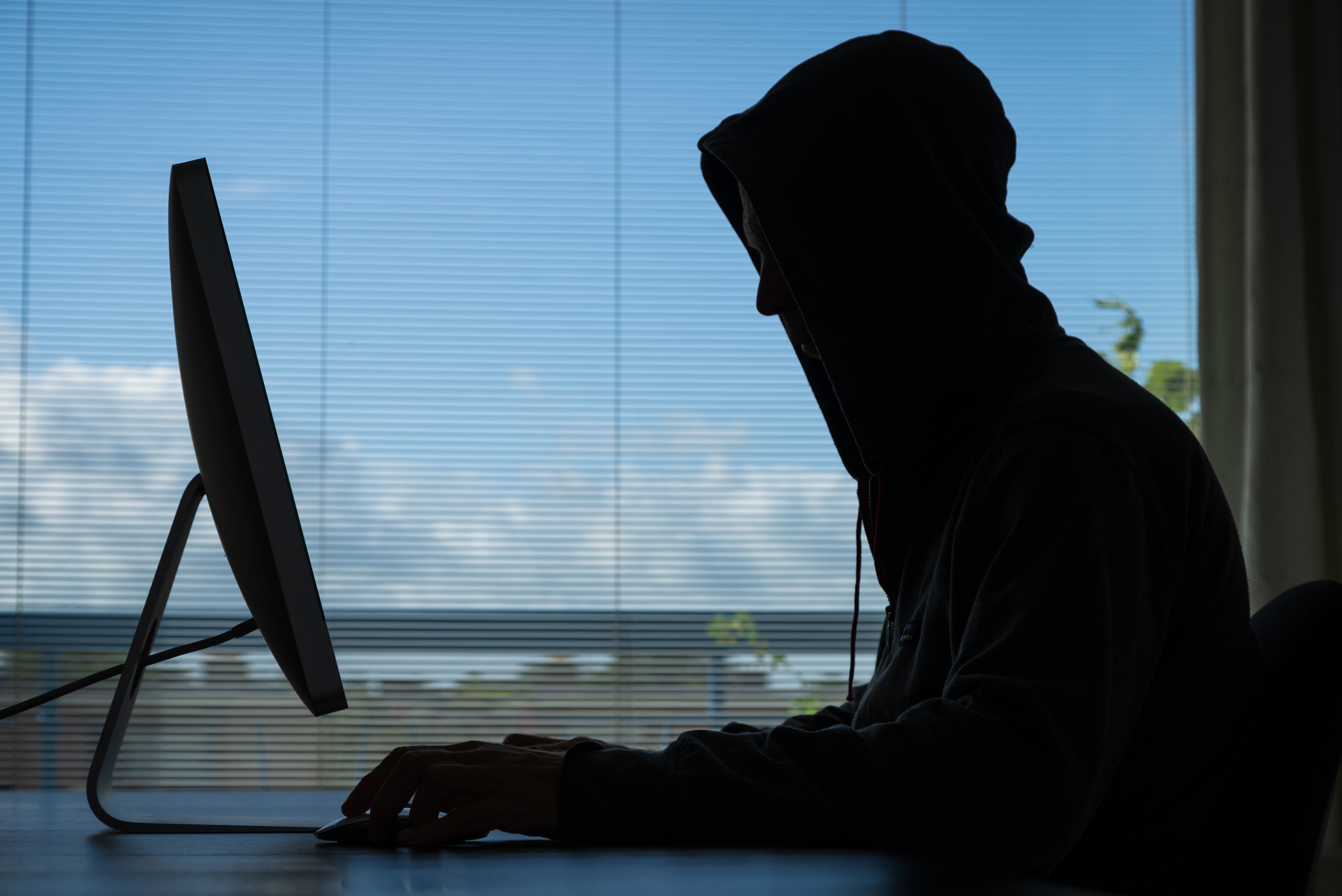 Person in hoodie working on computer