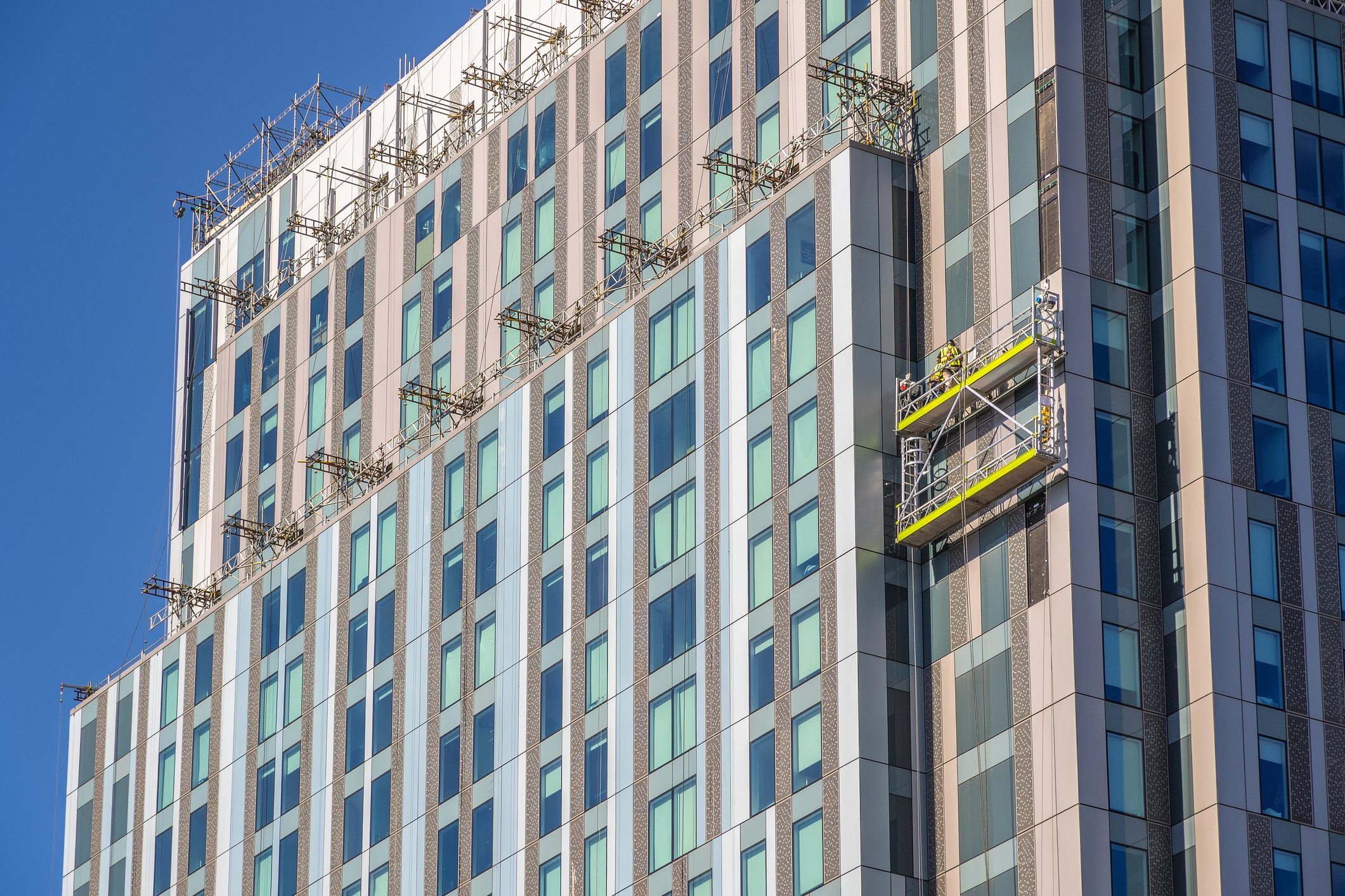 Construction workers on a building implementing cladding