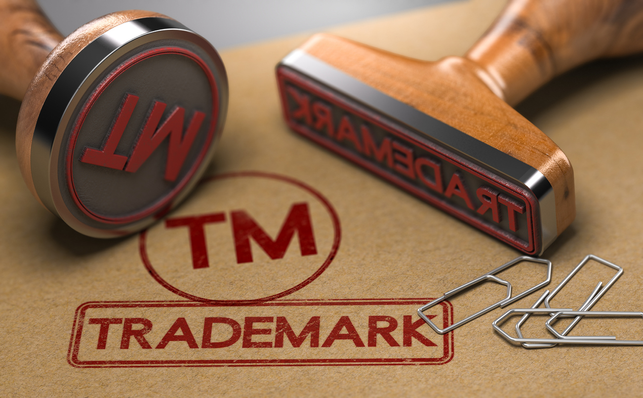 Two rubber stamps with the word trademark and the symbol TM over brown paper background